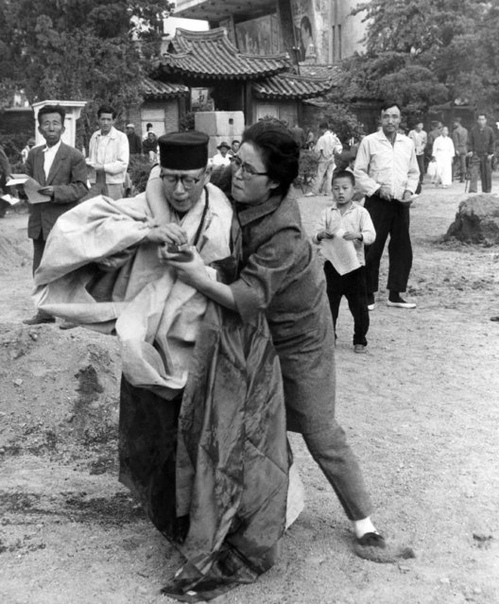 Женщина вырывает спички у буддийской монахини, облившей себя бензином. 